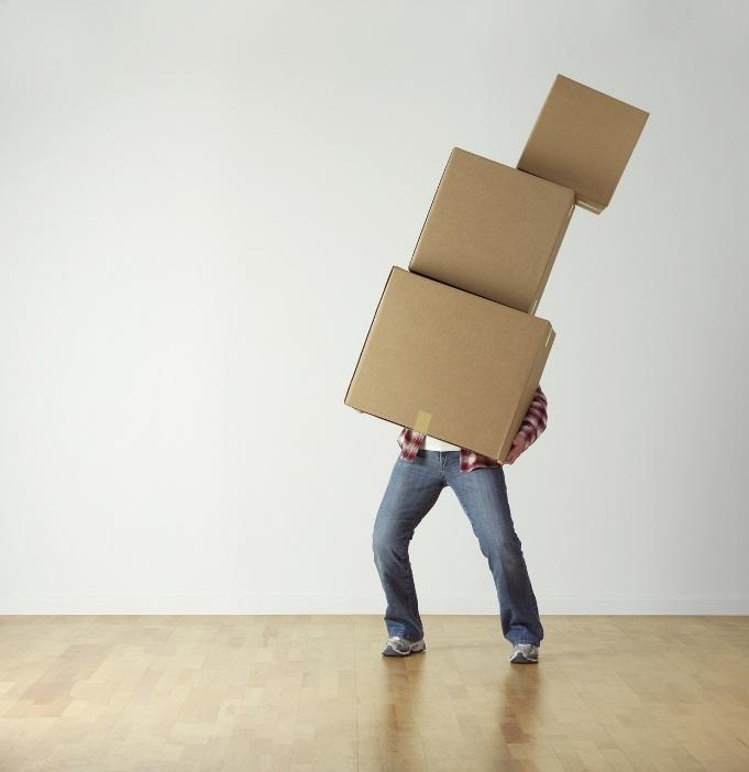 A man carrying packed cardboard boxes.