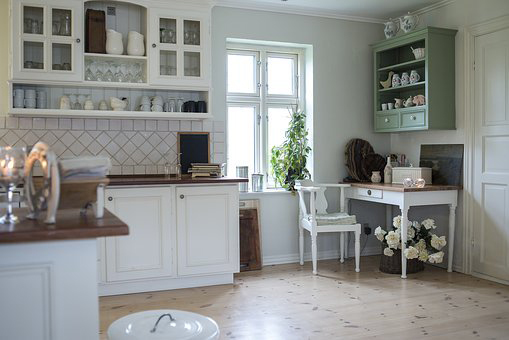 a beautiful light kitchen with many cabinets and lots of free space.