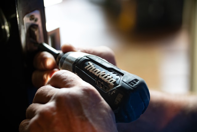 man's hands holding an electric screwdriver