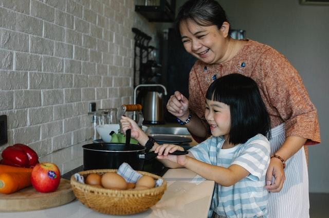 a grandmother and granddaughter cooking