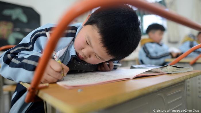 A Chinese schoolboy writes his homework