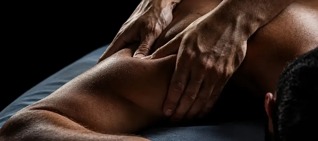 Licensed Elite Healers Sports Massage therapist performing a deep-tissue shoulder and mid-back release for a client at Elite Healers Sports Massage, the Midtown Manhattan performance recovery practice, located at 120 East 56th Street, Suite 420, New York, NY 10022.