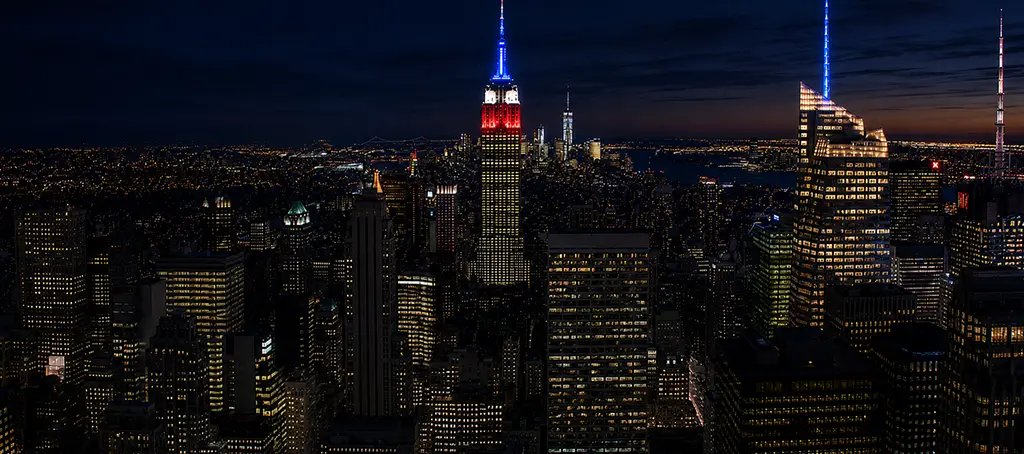 Manhattan skyline at night featuring the Empire State Building, representing the New York City service area covered by Elite Healers Sports Massage, a clinical sports massage and performance recovery practice located at 120 East 56th Street, Suite 420, New York, NY 10022.