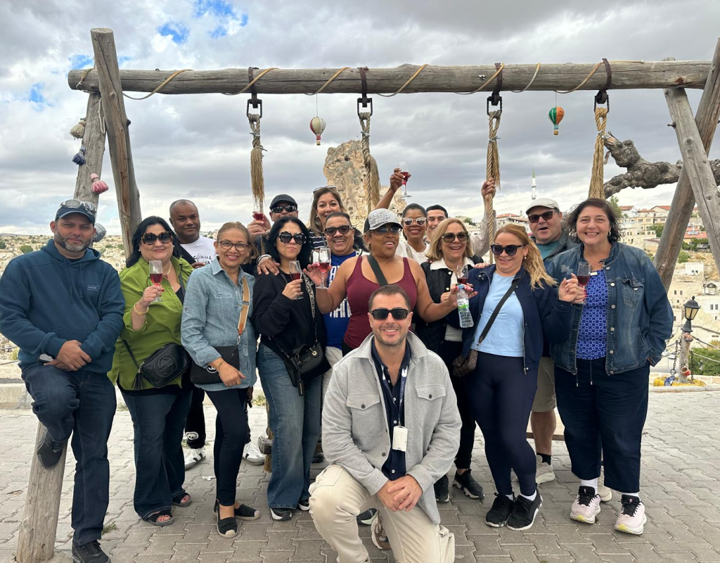 A smiling group of travelers enjoying a sunset city tour planned by a travel agency in Lodi.